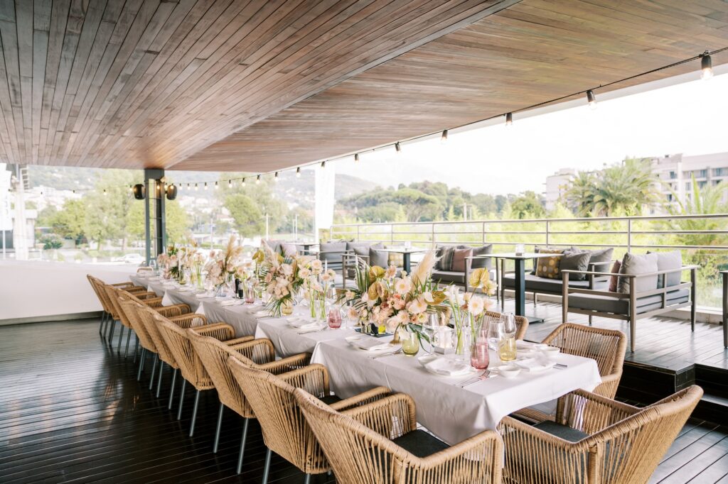 Long festive table on the restaurant terrace with panoramic views of the green park and houses